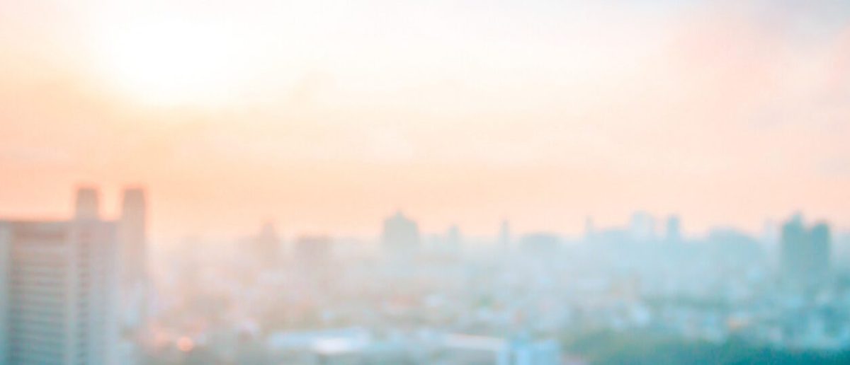 CatSci Green Chemistry: Image of a hazy city skyline with the sun and orange sky visible