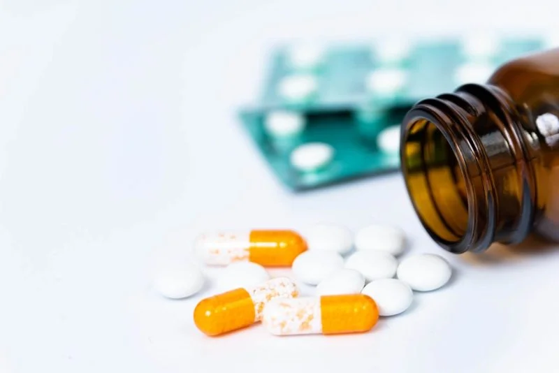 CatSci Blog The Nitrosamine Contamination Case: Image of white and capsule tablets, white tablets and an empty brown glass bottle
