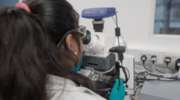 Female scientist looking in a microscope in a laboratory