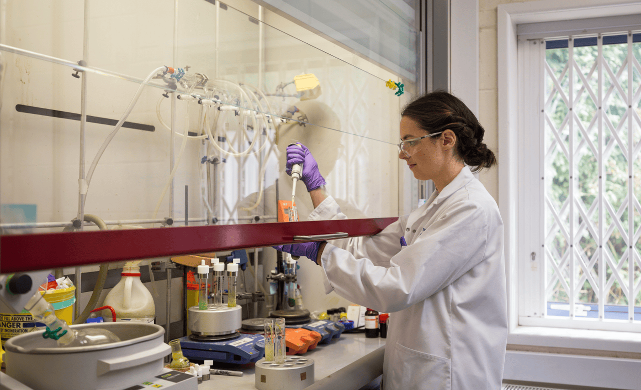 image of female scientist working on small molecule development in a chemical science laboratory working at a fumehood